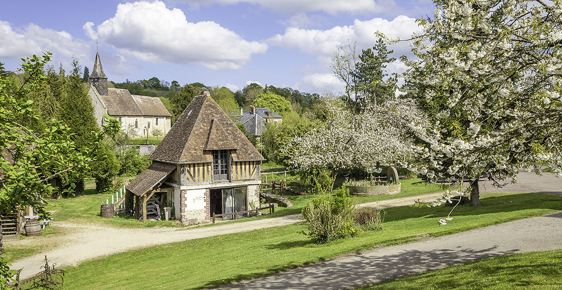 De vieilles maisons au toit de chaume entourée de pommiers