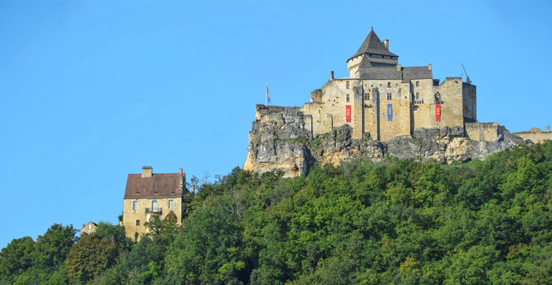 Le chateau de Beynac perché en haut d'une forêt