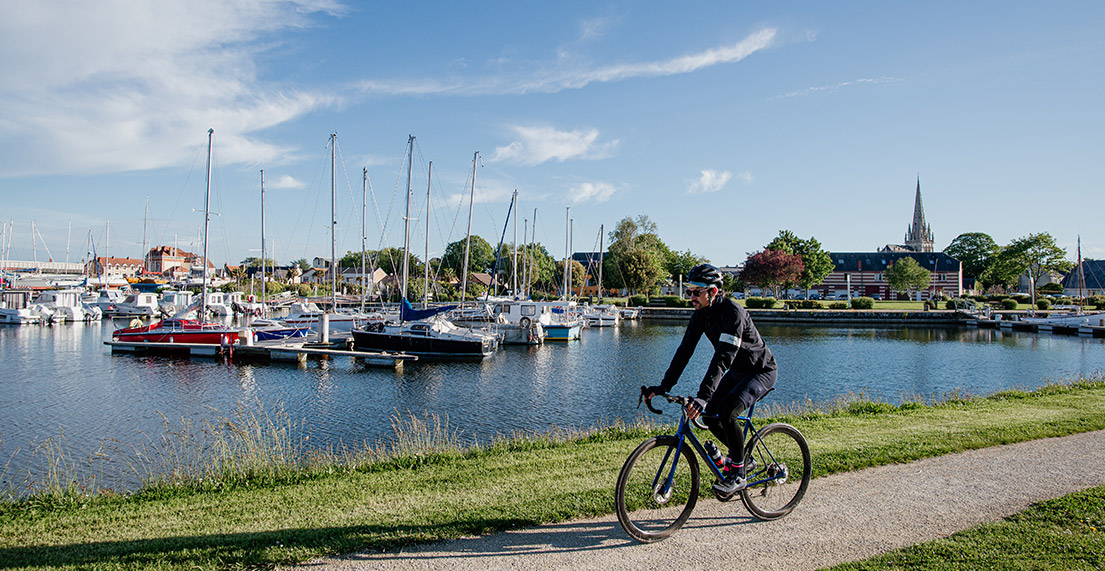 Un cycliste longe un port