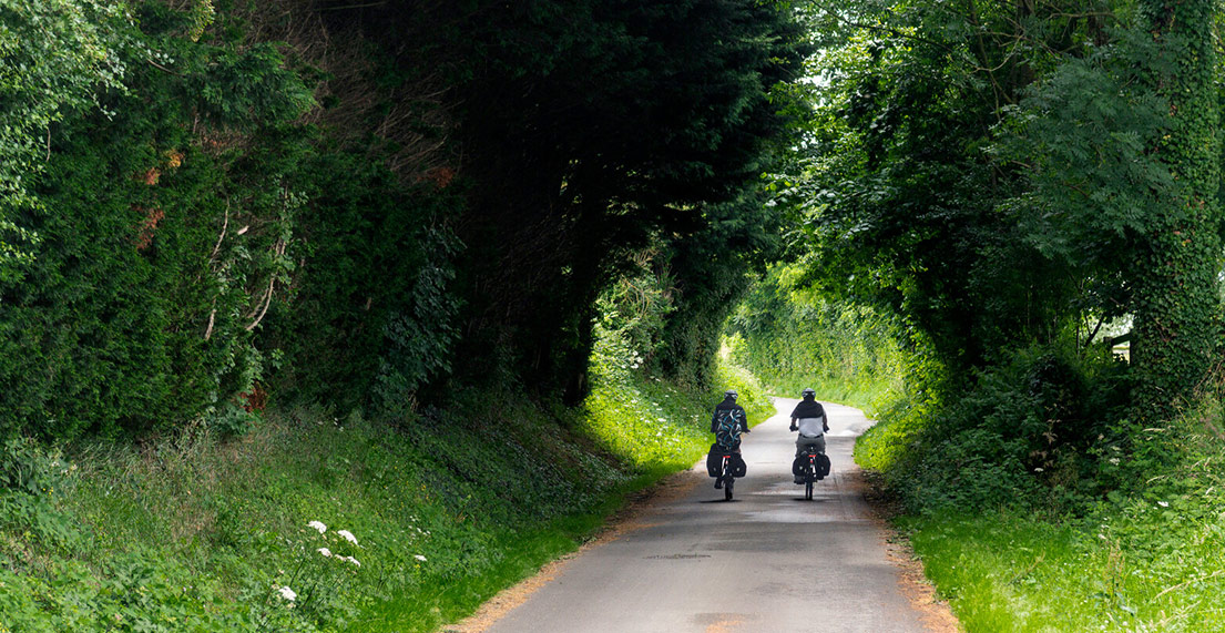 Un couple de cycliste roule sur les chemin de verdure de la Velomaritime