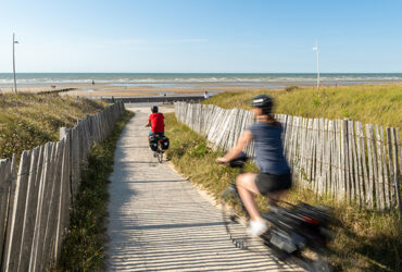 Une couple d cycliste roule en direction de la mer et de sa plage