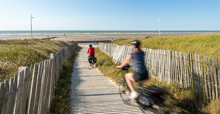 Une couple d cycliste roule en direction de la mer et de sa plage