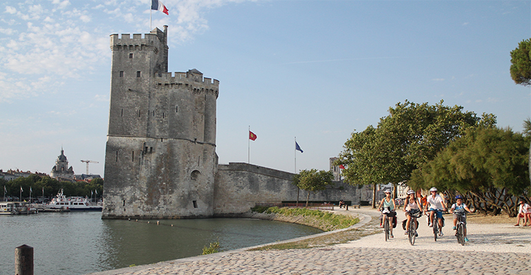 Une famille de cycliste roule sur les rues pavees de La Rochelle