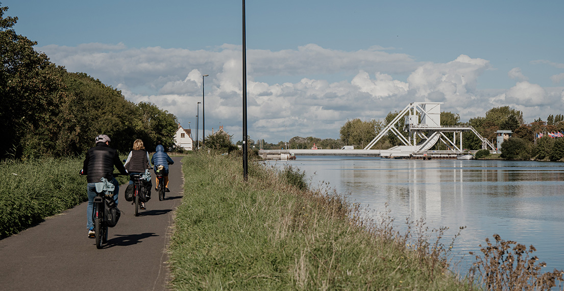 Une famille de cycliste longe un fleuve