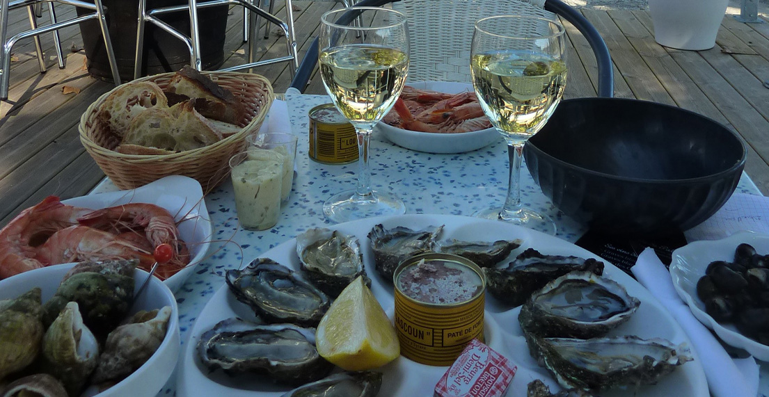 Un table avec vin blanc et fruits de mer