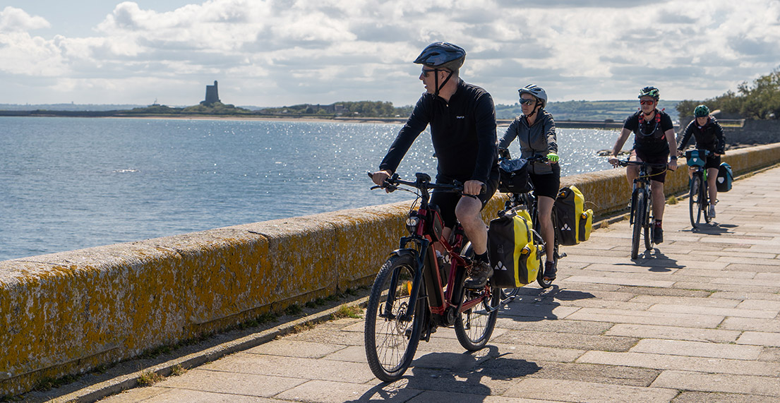 Un groupe de cyclistes roule le long de la mer