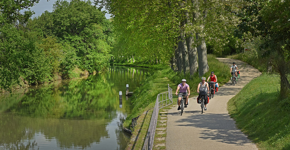 Une famille de cyclistes roule le long du canal