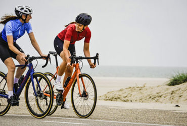 2 femmes cyclistes se regardent roulent devant la plage