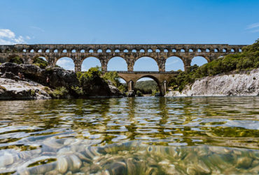 le pont du gard depuis la riviere sous le soleil