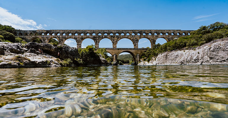 le pont du gard depuis la riviere sous le soleil