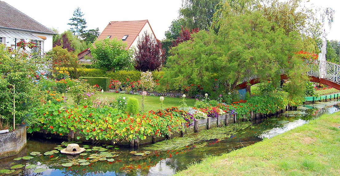 Une maison entouré d'un jli jardin fleuri