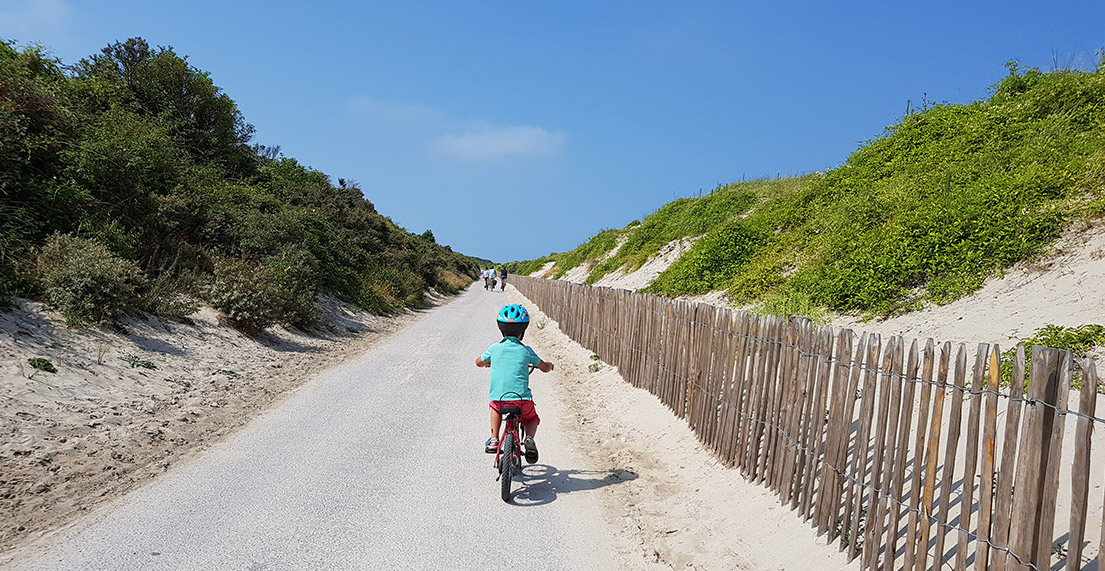 Un enfant roule sur le chemin cyclable blanc