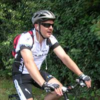 voyageur à vélo en t-shirt blanc et casque gris