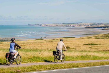 Un couple de cycliste roule le long du littoral normand et ses longues plages