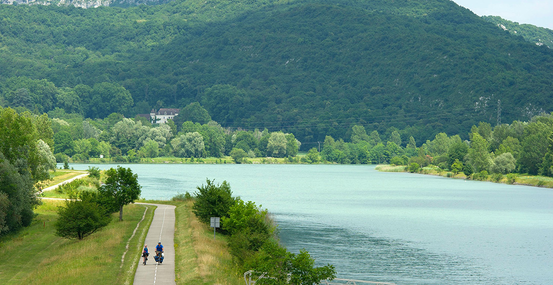 Un couple de cycliste roule sur un chemin cyclable au bord d'un lac