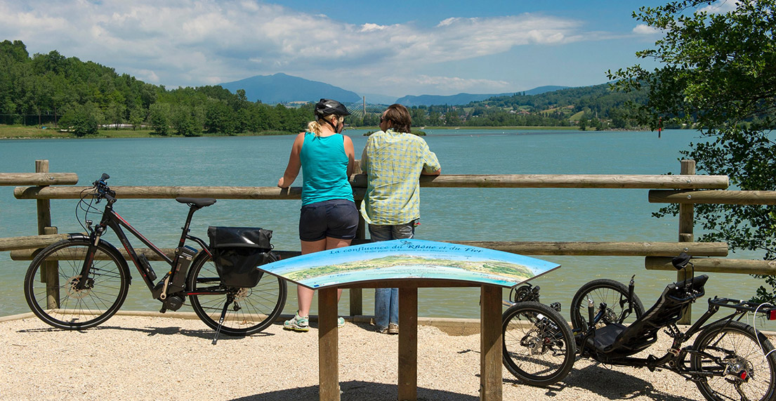 Deux cyclistes regardent une carte au bord d'un lac