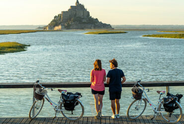 Cyclistes debout admirant le Mont Saint-Michel