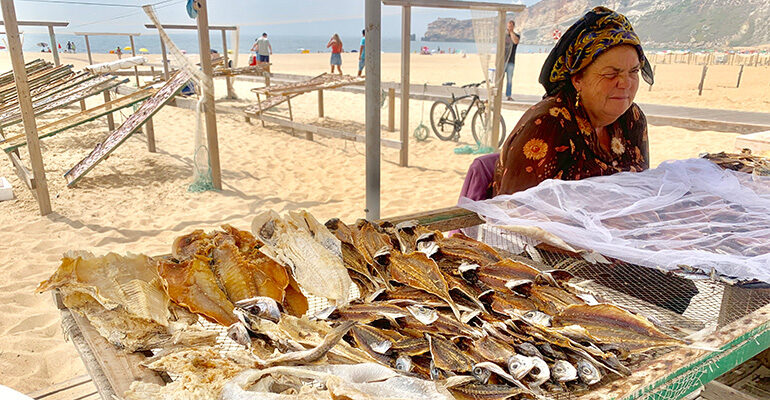 Vendeuse de poisson sur une plage au Portugal
