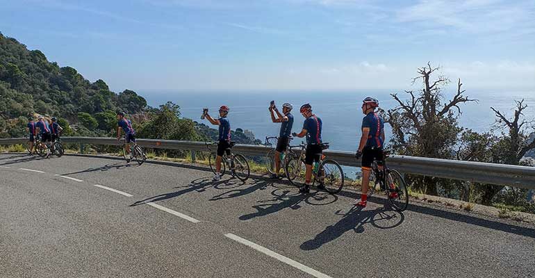 Cyclistes faisant une pause photo sur une route côtière de Catalogne