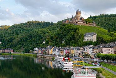 Bord de la Moselle village coloré et chateau surplombant sur la colline