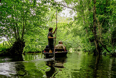 Un couple se baladant en barque sur la venise verte du Marais Poitevin