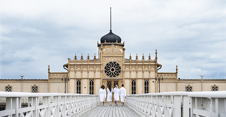 Un groupe de personne se dirige vers un magnifique bâtiment qui est un SPA