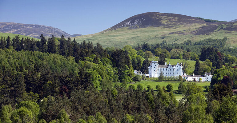 Vue sur la forêt et un grand château blanc, celui de Blair Castel