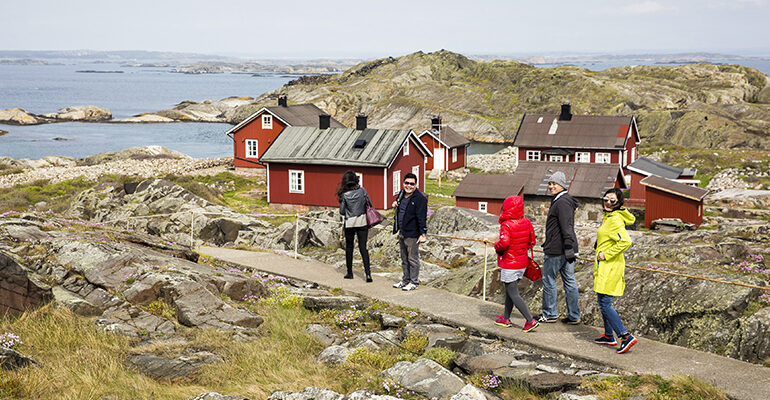 Un groupe de personne visite la côte et ses maisons typiques rouges