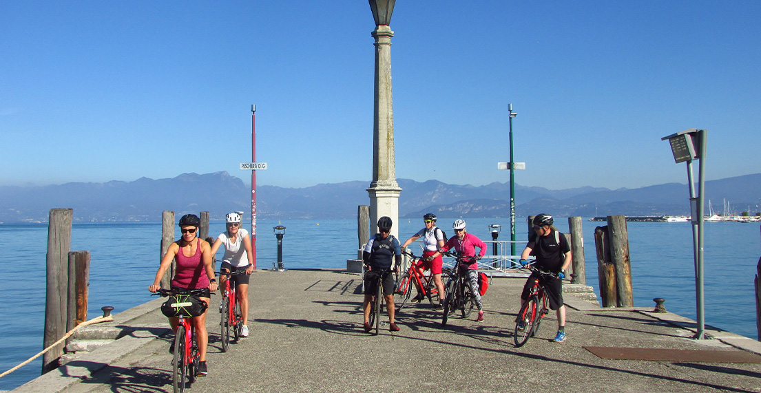 Un groupe de cycliste roule le long du Lac de Garde