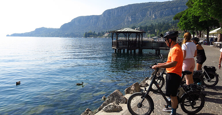 Des cyclistes admirent le paysage qu'offre le Lac de Garde