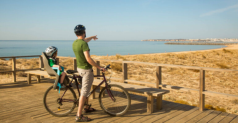 Un cycliste et son enfant admirent le littoral Portugais