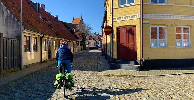 Un cycliste dans une rue pavée d'un village