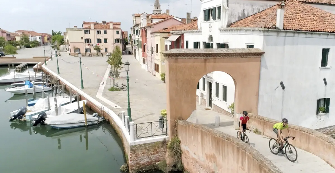 Deux cycliste traversent un pont dans une rue