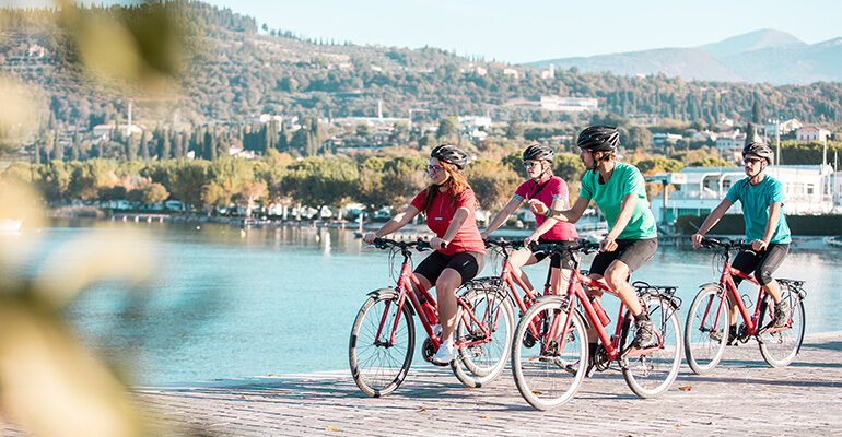 Un groupe de cyclistes roule le long du Lac de Garde