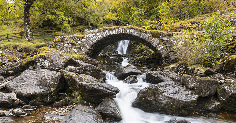 Un rivière passant en dessous d'un pont en pierre