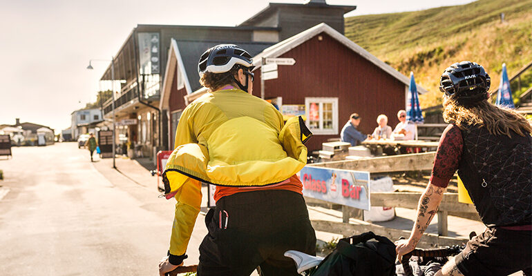 Deux cyclistes traversent une ville typique de Suède