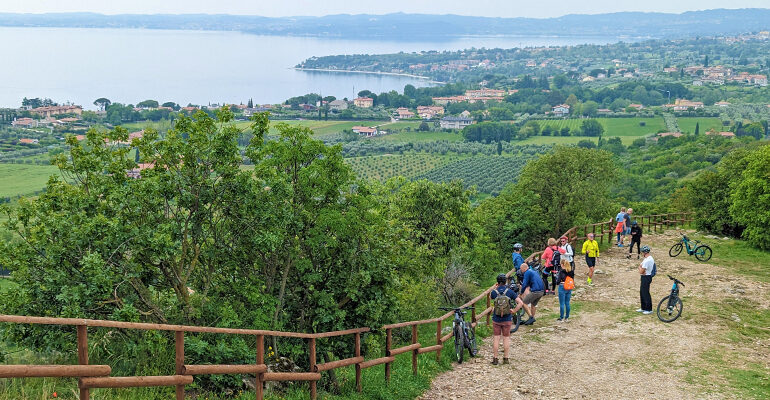 Un groupe de cycliste admire la vue sur une vallée Italienne
