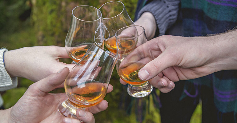 4 personnes triquant lors d'une dégustation de whiskey