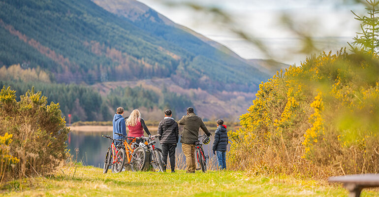 Un groupe de personnes et leurs vélo admirant la vue sur un lac
