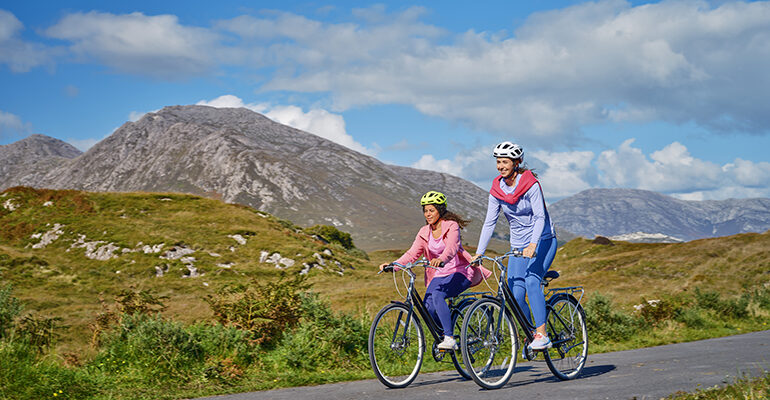 Deux cyclistes sur une route entourée de montagnes