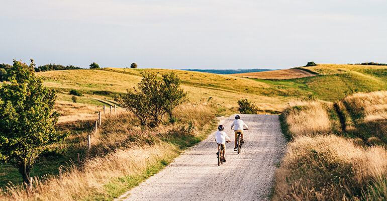 Deux enfants cyclistes roulent sur une piste cyclable de campagne