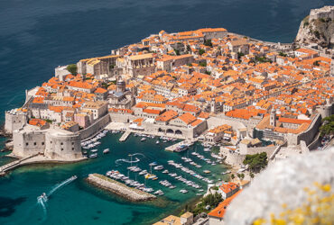 Vue aérienne de la ville de Dubrovnik et son port entouré d'une mer turquoise