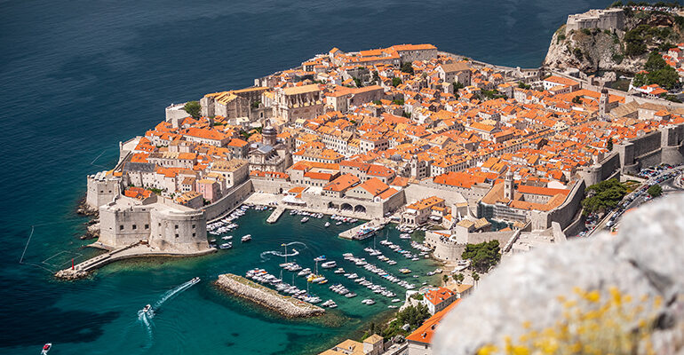 Vue aérienne de la ville de Dubrovnik et son port entouré d'une mer turquoise