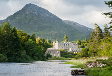 Un paysage montagneux surplombe un château blanc et son lac