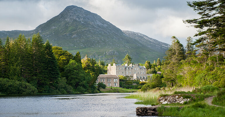 Un paysage montagneux surplombe un château blanc et son lac