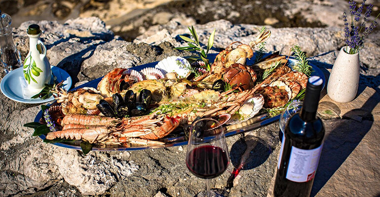 Plateau de fruits de mer accompagné d'huile d'olive et de vin rouge