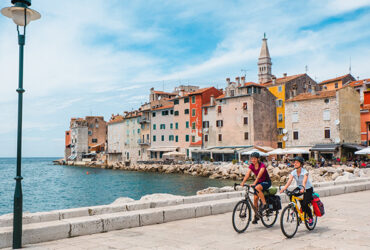 Deux cyclistes sur le port aux maisons colorées de Rovinj