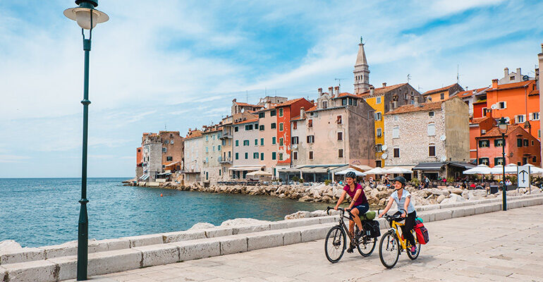 Deux cyclistes sur le port aux maisons colorées de Rovinj
