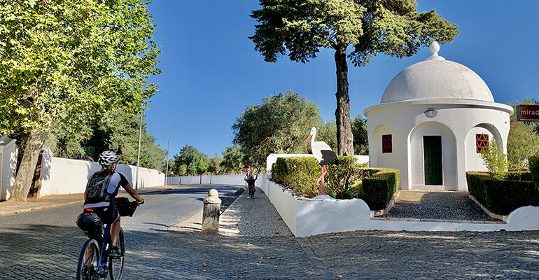 Une cycliste roule dans un village Portugais