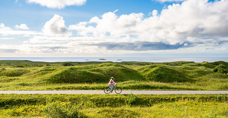 Une cycliste se promène dans les routes entourées de verdure